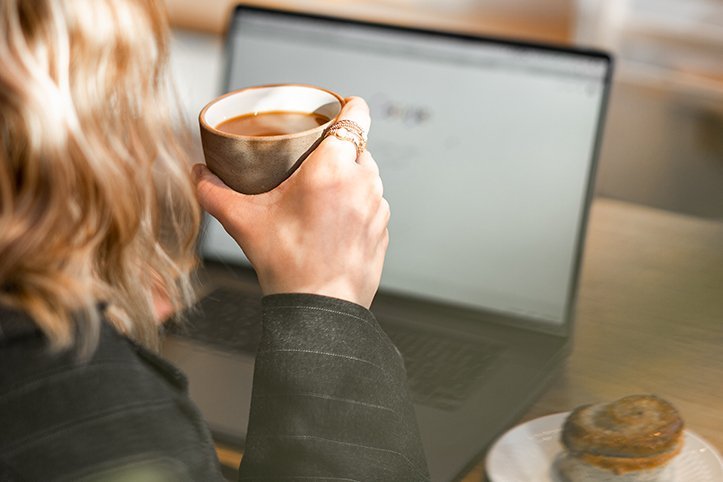 Frau mit Kaffee nimmt an Online-Veranstaltung teil